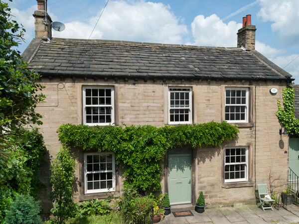 A traditional home with sliding sash windows and a green front door